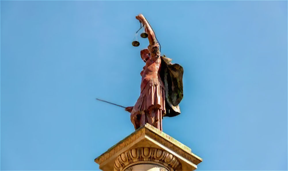 Statue of Lady Justice against a blue sky.